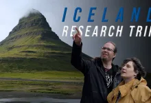 Two Euro Truck Simulator 2 team members stand in front of a distinctive Icelandic mountain during a research trip.