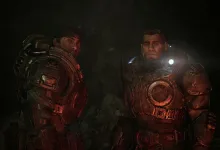 Two armored Gears of War: E-Day characters stand in a dark cavern illuminated by red and white light.