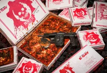 A square pizza surrounded by Prince St. Pizza boxes and a Prototype Lancer-style pizza cutter