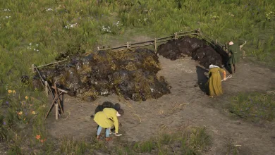 Workers tend a field beside a large dung pile in Manor Lords
