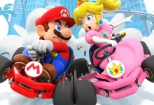 Mario and Princess Peach race in red and pink karts on a city course in Mario Kart Tour.