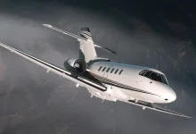 FlightFX Hawker 800XP business jet flying above a dark mountainous landscape in Microsoft Flight Simulator 2024.
