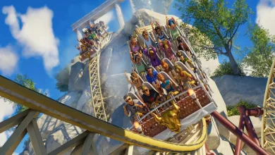 A roller coaster car carries riders around a steep track at a bright outdoor amusement park.