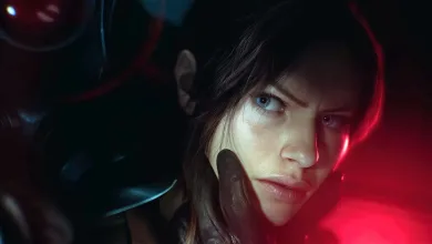 Close-up of a woman in dark clothing, her face illuminated by red and blue light.