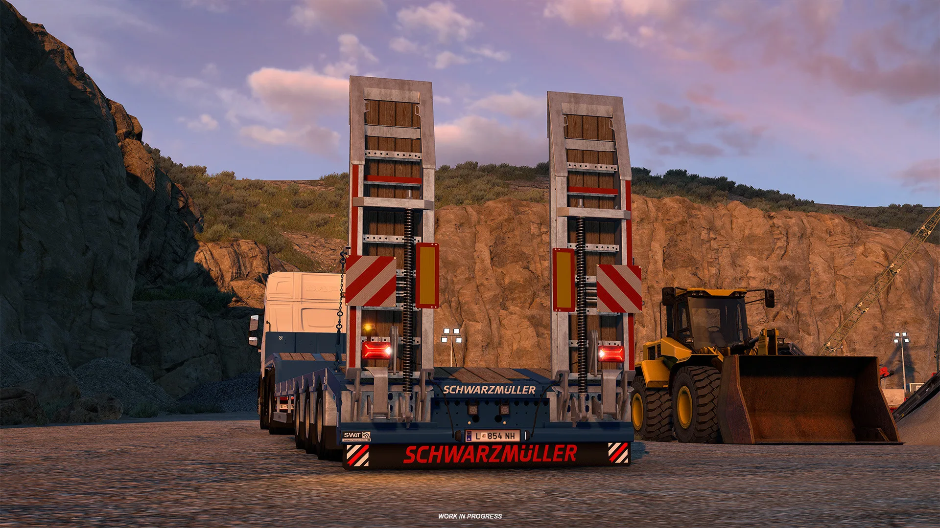 Schwarzmüller low loader trailer carrying construction equipment at a quarry