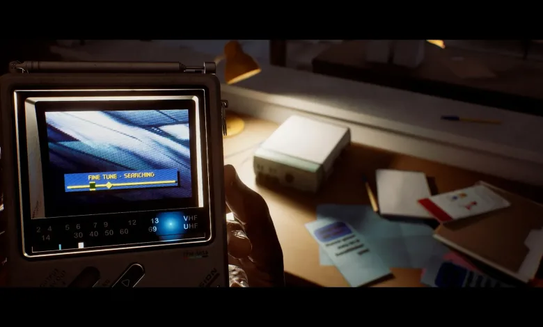 A first-person view shows a hand holding the CRTV handheld device over a desk in Silent Hill: Townfall