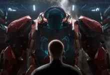 A young soldier seen from behind faces a towering red armored mech in a futuristic hangar.