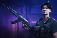 A THE FINALS contestant in dark tactical gear holds a rifle in a blue-lit interior.