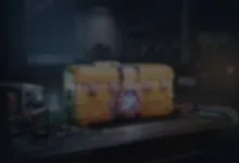A blurred yellow reward crate sits on a surface in a dark industrial setting.