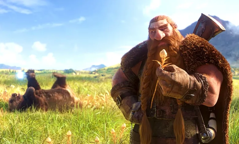 A bearded dwarf holding a small flower stands in a sunlit meadow with mountains in the background.