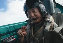 Kazutoki Kono smiles and gestures from inside a fighter-jet cockpit during his MiG-21 ride.