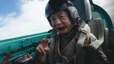 Kazutoki Kono smiles and gestures from inside a fighter-jet cockpit during his MiG-21 ride.