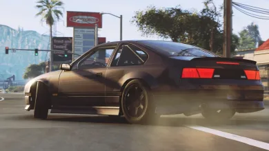 A dark coupe turns across a city street in BeamNG.drive, kicking up dust behind it.