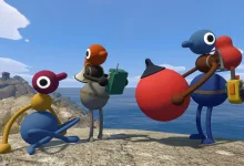 Four colorful Big Walk characters stand and sit on a rocky coastal overlook beside the sea.