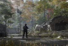 A lone operator stands before tents and equipment at a wooded military outpost.