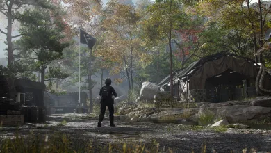 A lone operator stands before tents and equipment at a wooded military outpost.