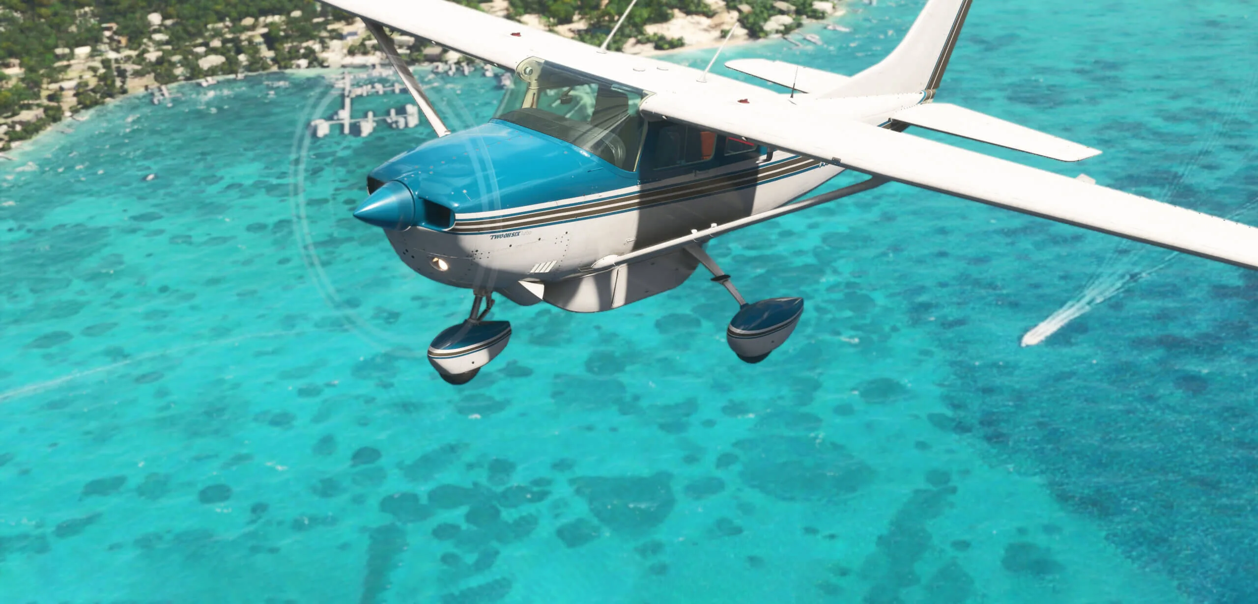 Carenado CT206 equipped with floats flying over turquoise water