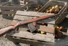 A wooden-stock rifle with a large magazine rests across wooden crates in Enlisted.