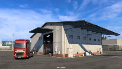 A red truck parked outside a large garage in Euro Truck Simulator 2.