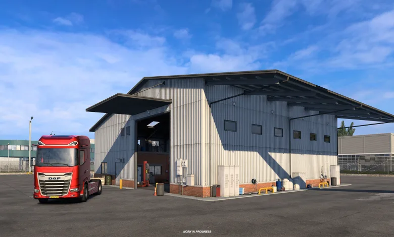 A red truck parked outside a large garage in Euro Truck Simulator 2.