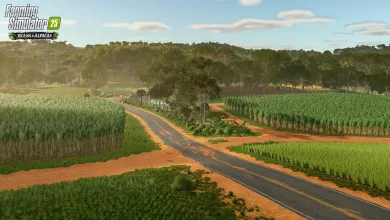 A paved road winds through green fields and red soil beneath a forested skyline in Farming Simulator 25.