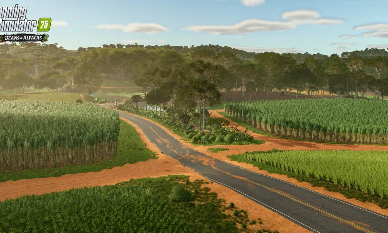 A paved road winds through green fields and red soil beneath a forested skyline in Farming Simulator 25.