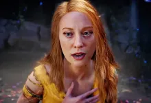 Close-up of red-haired Faye wearing yellow in a shadowy game environment.