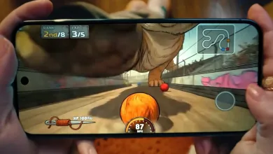 A smartphone held in two hands displays a colorful racing game with a speedometer and track map on screen.