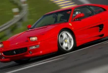 A red Ferrari F355 races around a circuit in Gran Turismo 7.