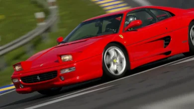 A red Ferrari F355 races around a circuit in Gran Turismo 7.