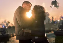 Jason and Lucia embrace by a waterway at sunset, with boats and a helicopter nearby.