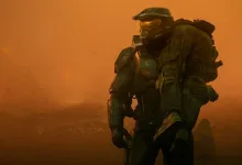A green-armored Halo Spartan kneels in an orange haze.