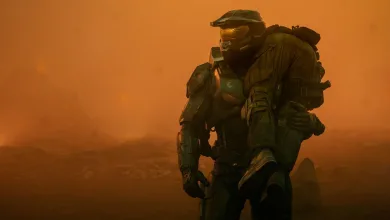 A green-armored Halo Spartan kneels in an orange haze.