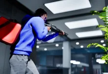 A character in a blue hoodie aims a shotgun inside a building in Hood Warfare 2.