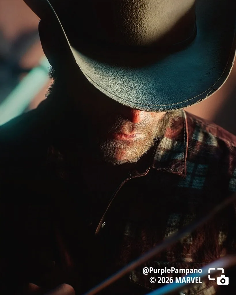 Logan tips his hat down in a close portrait