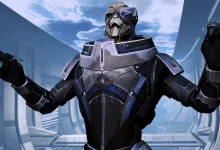 Garrus stands with both hands raised in a bright futuristic interior.
