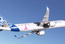 An Airbus A321LR airliner with blue-and-white Airbus livery flies against a clear blue sky in Microsoft Flight Simulator 2020.