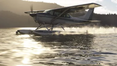 A Carenado CT206 on amphibious floats skims across a lake, throwing up spray.