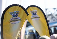 Yellow Pokémon GO Community Ambassador Program flags at an outdoor event.