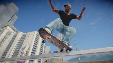 A skate. skater in a black shirt and light jeans performs a skateboard trick above a ledge against a blue sky.