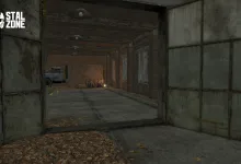 An abandoned garage interior seen through open metal doors, with a truck and crates inside.