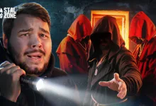 A flashlight-bearing man stands before a hooded figure and red-robed companions.
