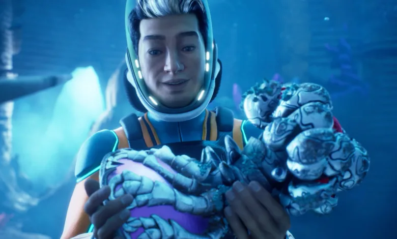 A diver in a Subnautica 2 suit holds a pale alien creature underwater.