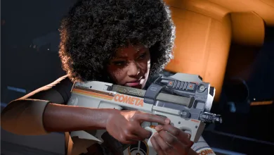 A COMETA-marked contestant holds a futuristic weapon in THE FINALS.