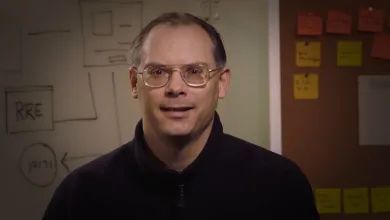 Tim Sweeney speaking in an office in front of a whiteboard and notes.