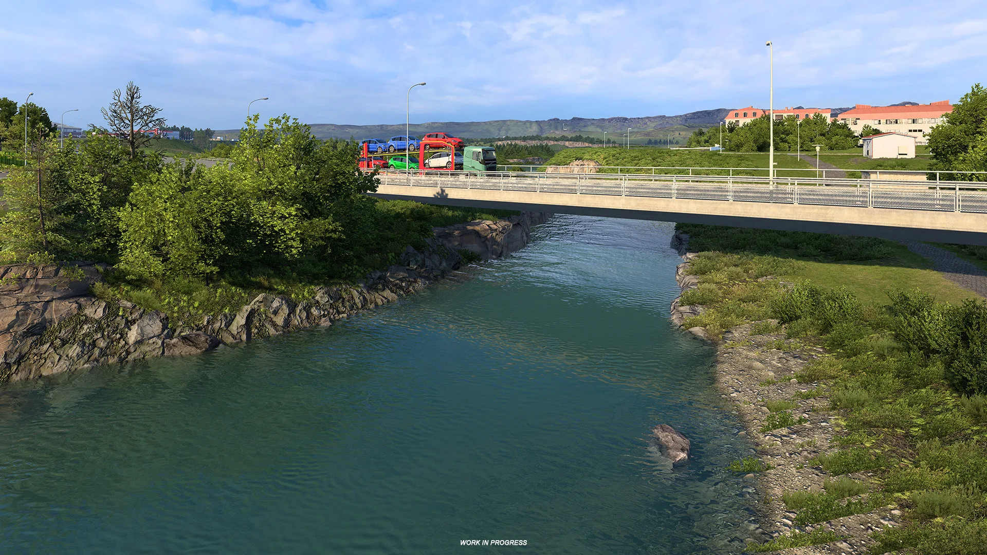 Truck crossing a bridge above shallow water and visible river rocks