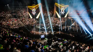 A packed esports arena with VALORANT Champions banners above the stage.