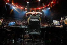 VALORANT Champions player seated at a gaming station onstage beneath arena lights