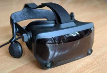 A Valve Index VR headset with its head strap, side speaker, and front sensors resting on a wooden table.