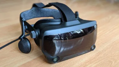 A Valve Index VR headset with its head strap, side speaker, and front sensors resting on a wooden table.